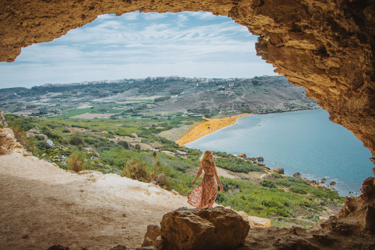 Image of a girl with her back to us looking out at the sea below
